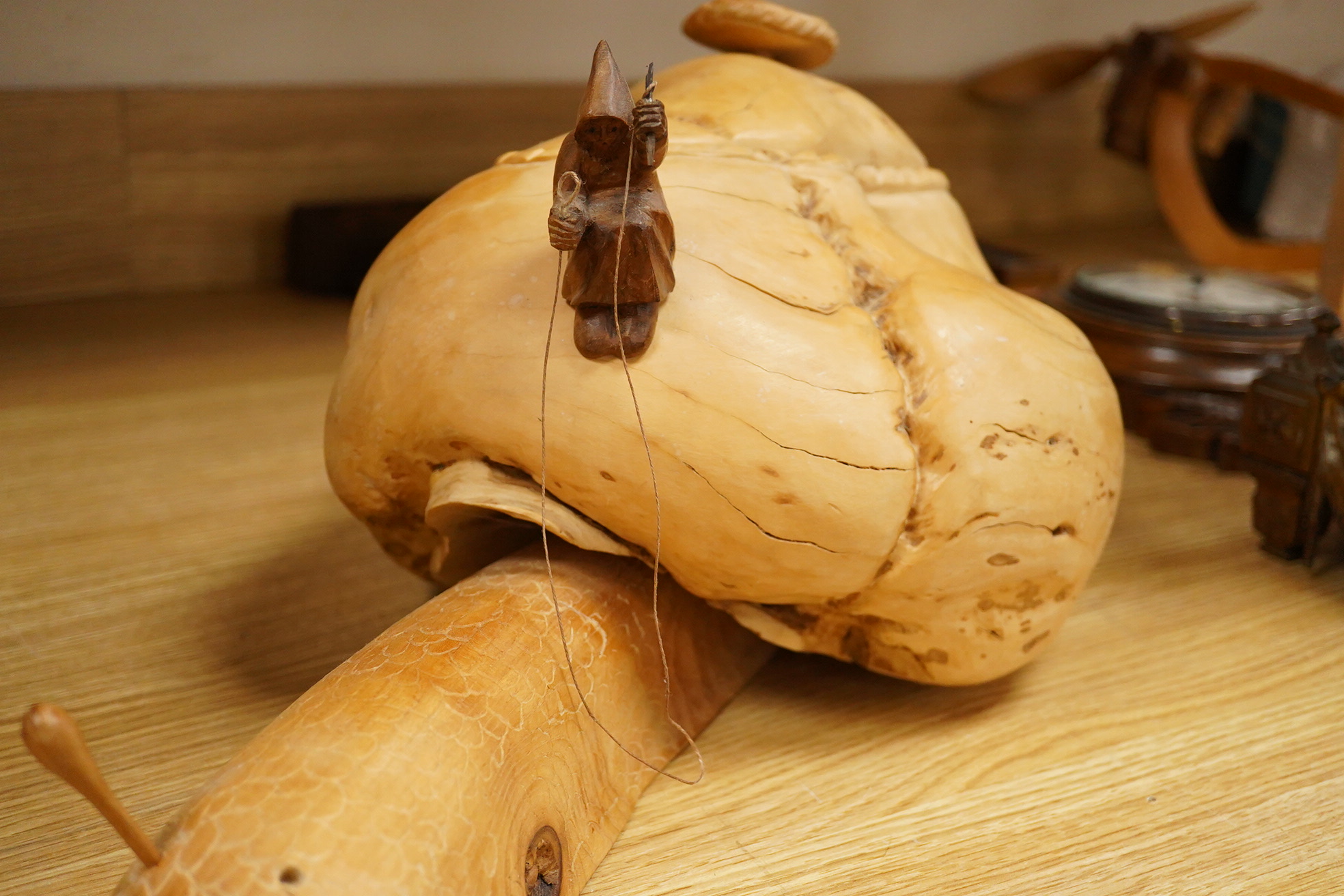 Pierre Decorse (b.1953), a naturalistically modelled wooden sculpture depicting a figure riding a snail, 53cm long